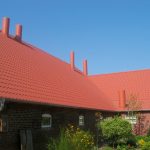 Agricultural building with profiled sheets in the form of tiles